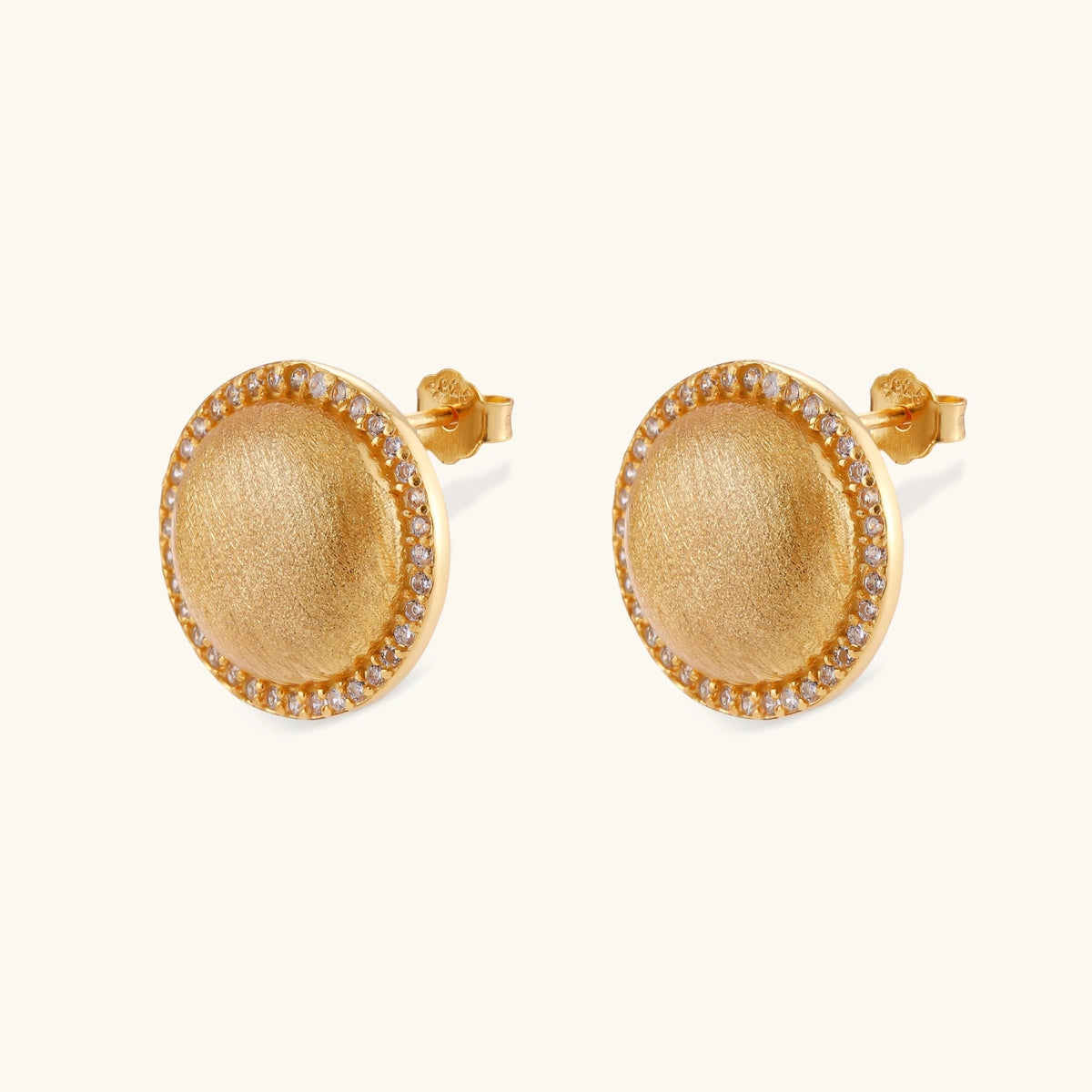Pair of round dome stud earrings in brushed 18K gold-plated silver with a sparkling CZ halo border, push-back closure.